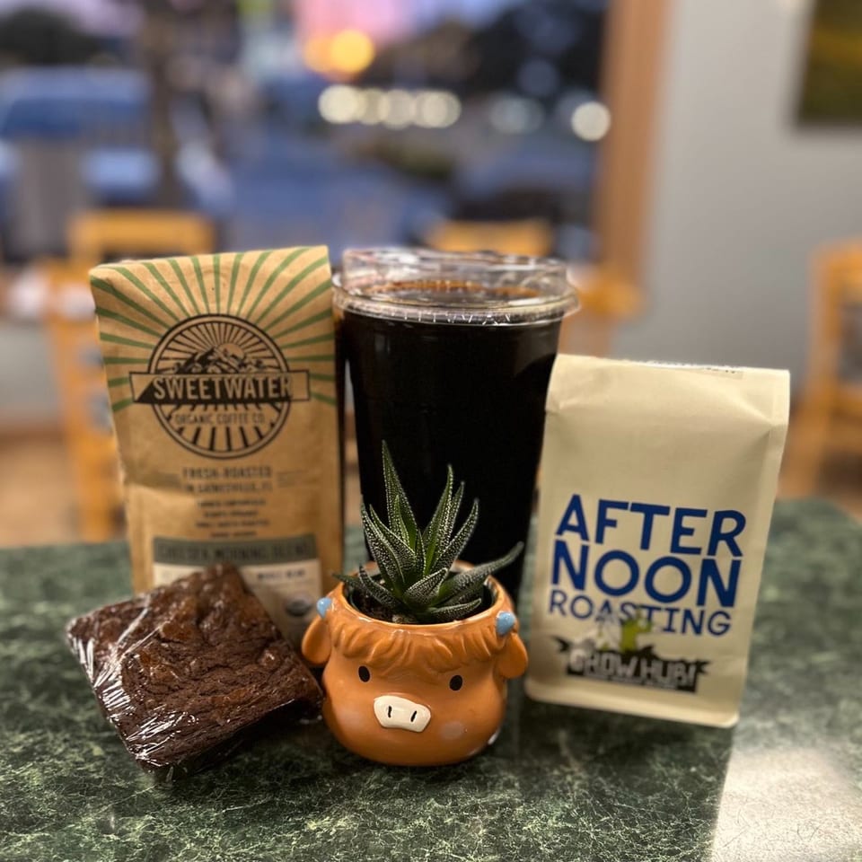 Chelsea Coffee Company's Sweetwater coffee bag, iced coffee, brownie, and a succulent in a cow planter.